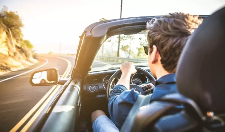 mann-der-in-cabrio-über-eine-landstraße-faehrt